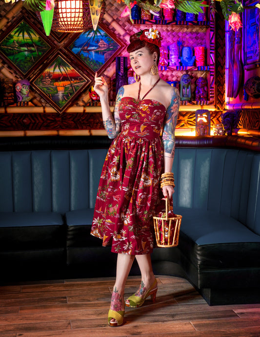 Woman in a colorful dress holding a basket in a vibrant bar setting