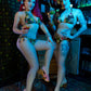 Two women in colorful outfits sitting in a bar.