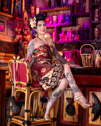 Woman with tattoos sitting in a bar with colorful decor