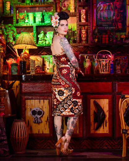 Woman with tattoos standing in a colorful bar setting