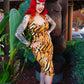 Woman in a tiger print dress standing next to a large statue outdoors