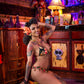 Woman with tattoos posing in a bar setting wearing a bikini