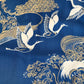 Decorative fabric with gold and white crane patterns on a blue background