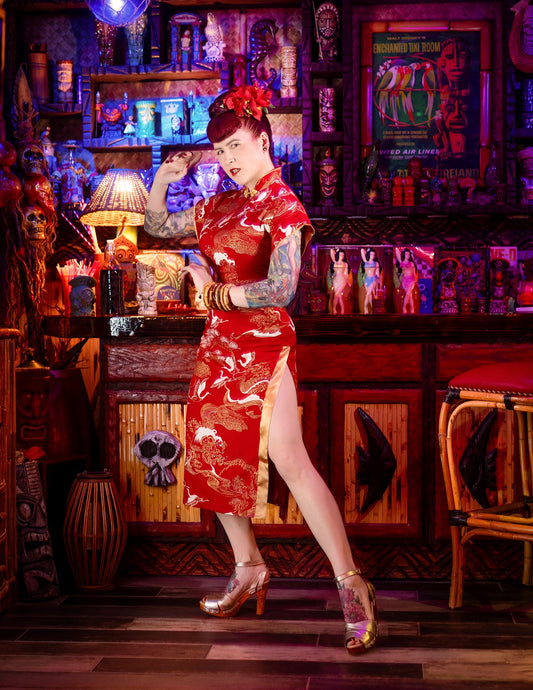 Woman in a red dress standing in a bar with vintage decor
