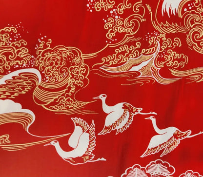 Decorative fabric with white cranes and gold patterns on a red background